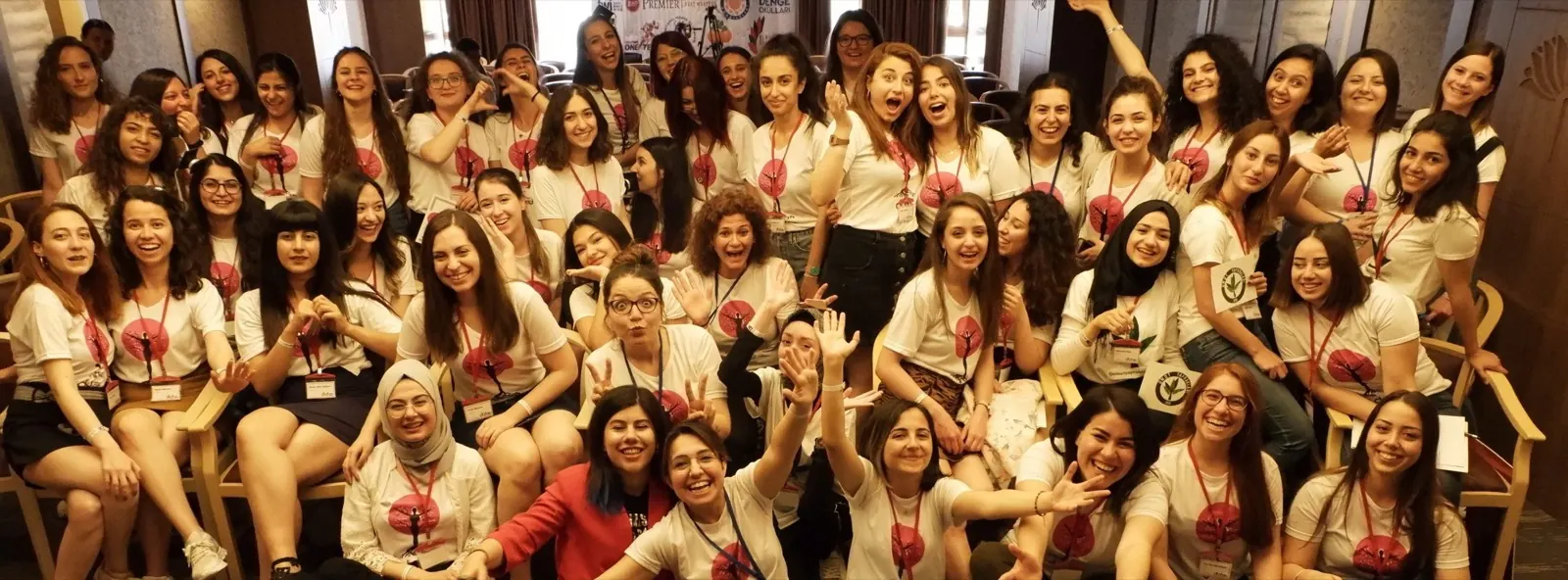 2019 Kıvılcımlar Zirvesi: beyaz tişörtlü onlarca genç kadın salonda el sallıyor